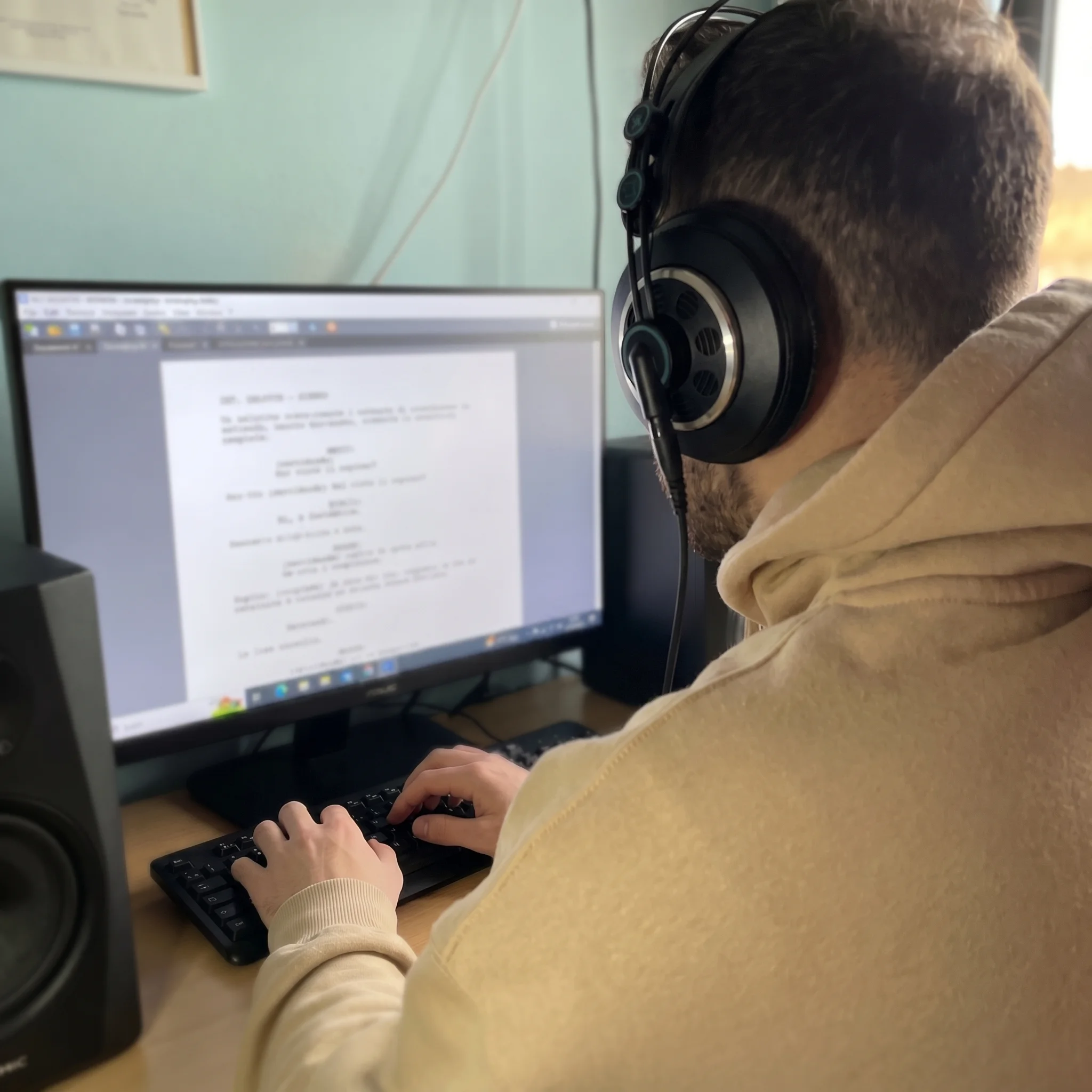 Persona che scrive su laptop su scrivania con luce naturale